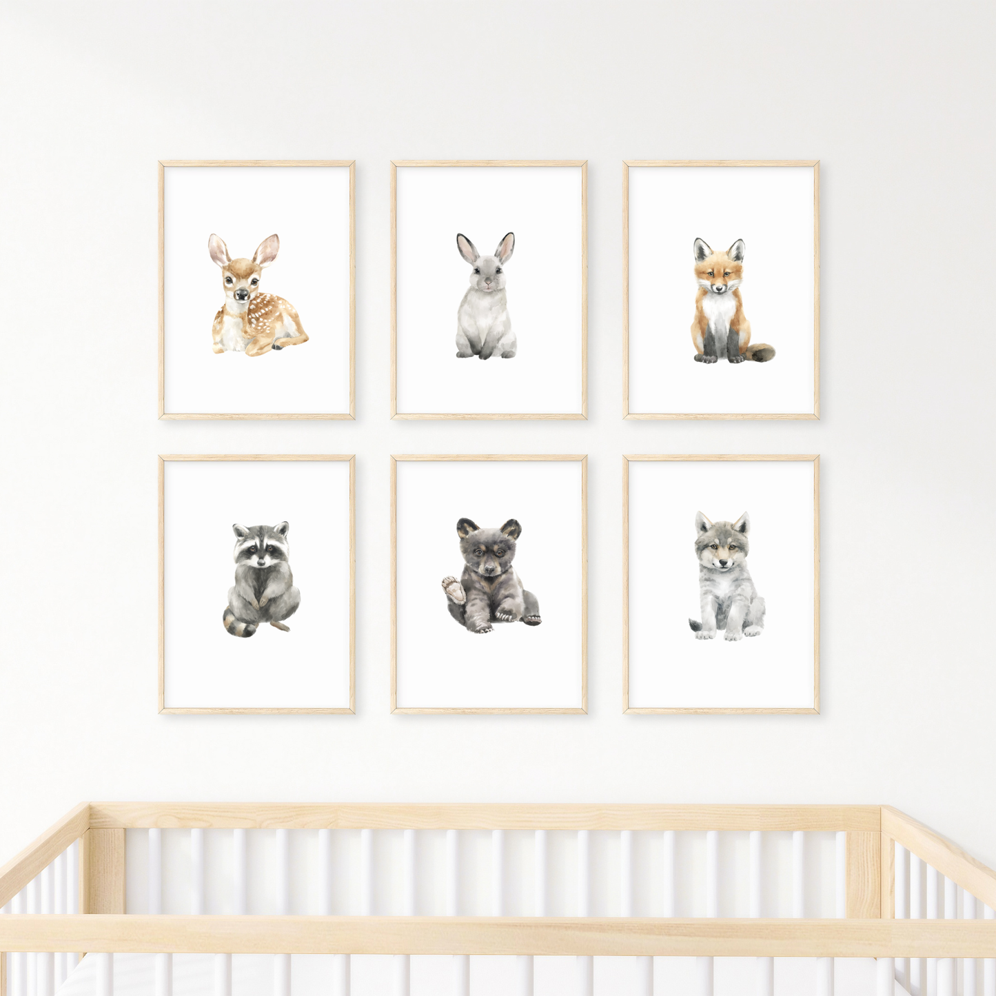Set of six framed woodland animal prints on a wall above a crib - baby nursery decor