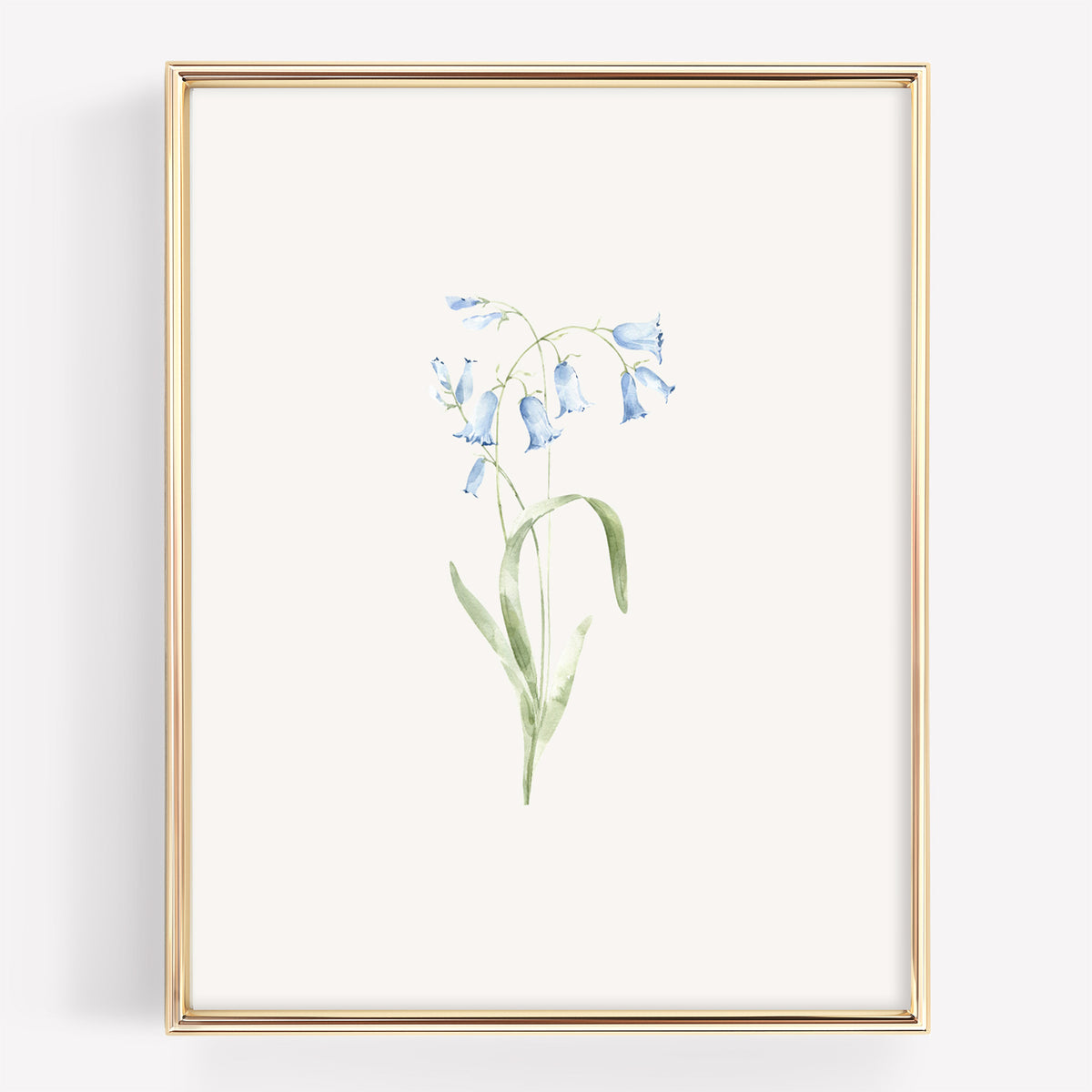 A framed botanical art print featuring a delicate watercolor illustration of light blue bellflowers with green stems on an off-white background, enclosed in a thin gold frame.