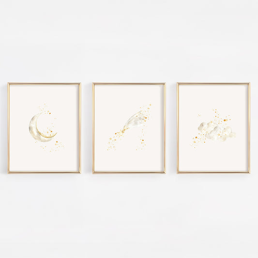 Set of three celestial nursery art prints in gold frames featuring a crescent moon with stars, a whimsical shooting star, and soft clouds with twinkling stars.