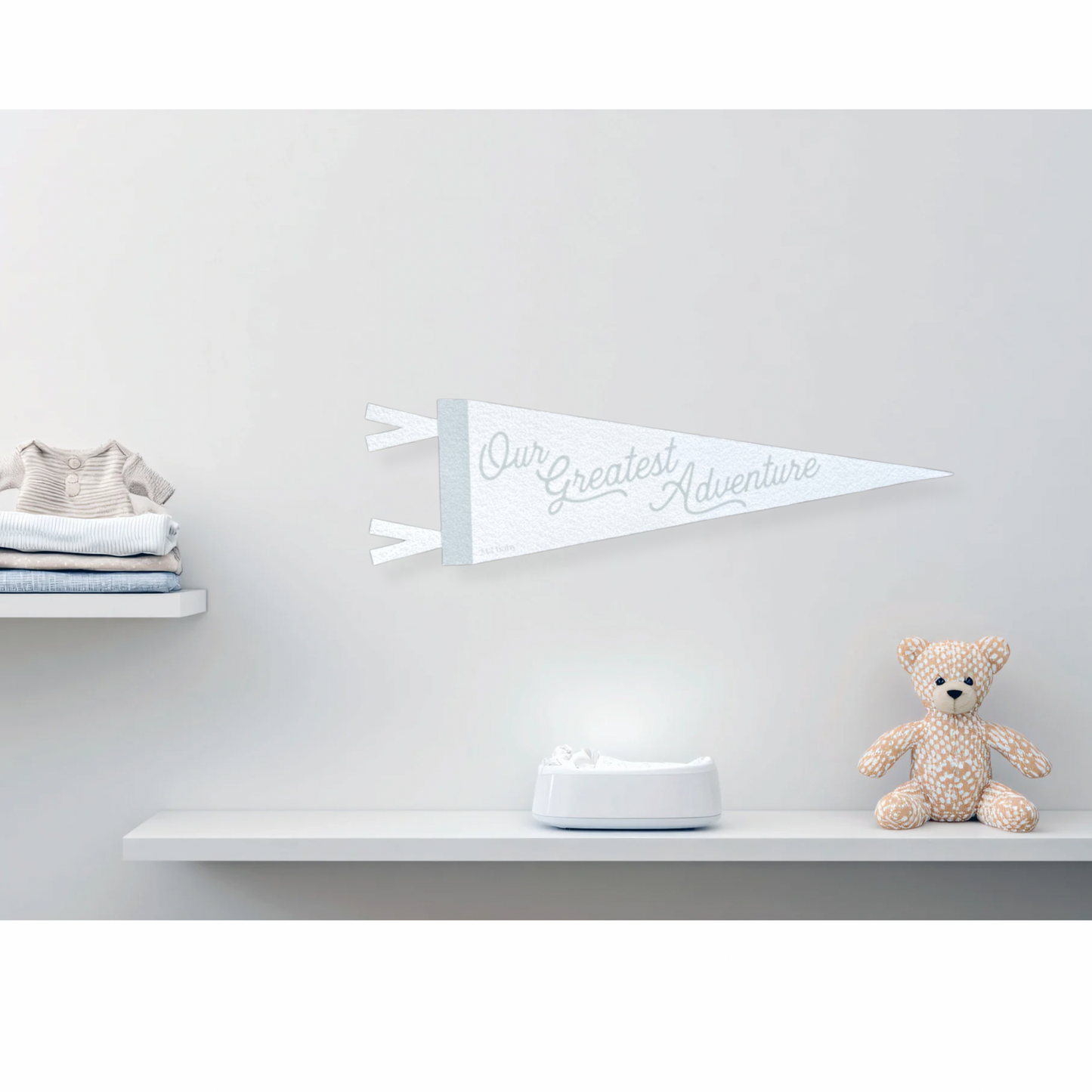 Grey and white decorative felt pennant baby banner against a light gray wall.