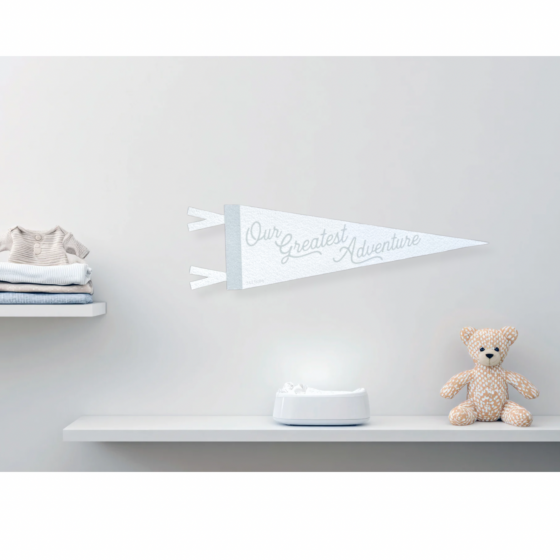 Grey and white decorative felt pennant baby banner against a light gray wall.