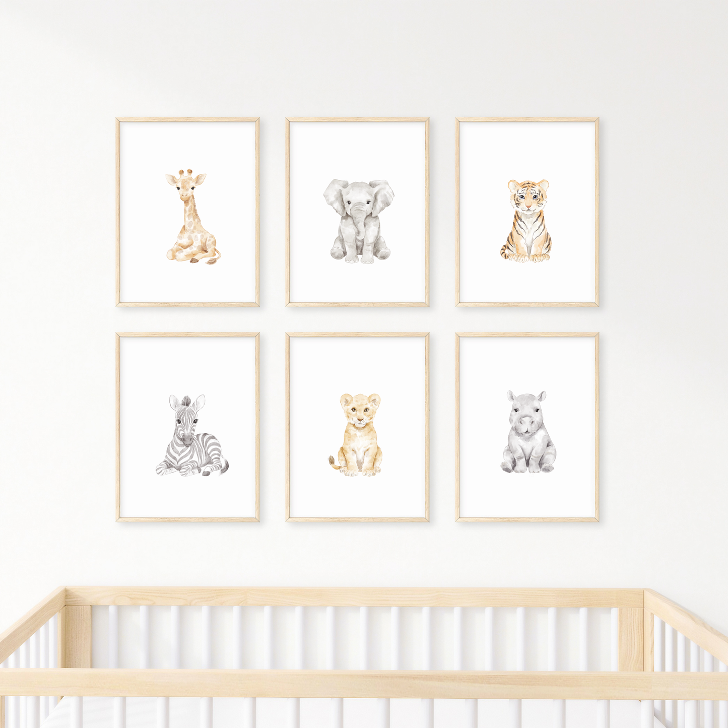 Set of six framed safari animal prints on a wall above a crib