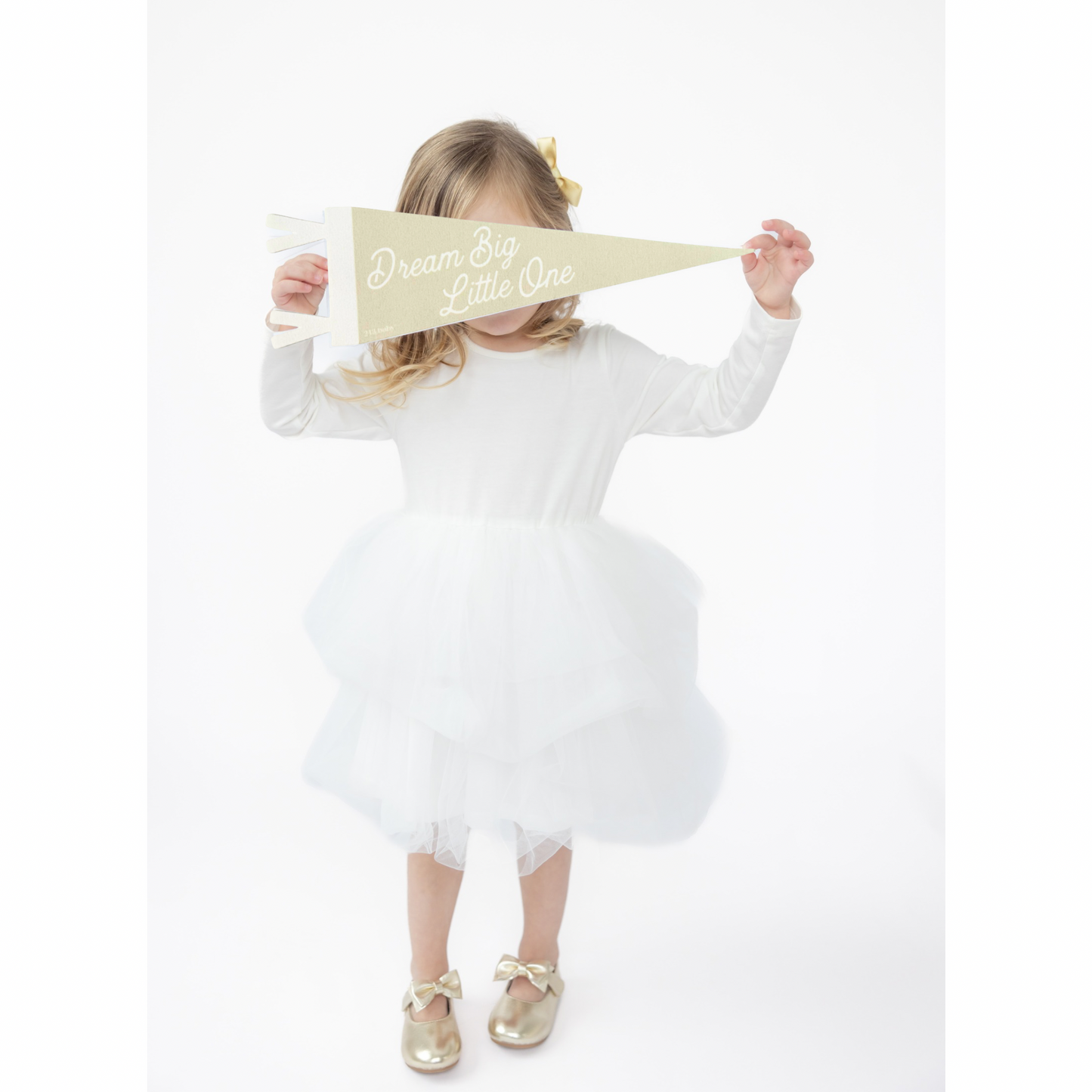 Child in a white dress holding a gold banner baby nursery decoration with text on a white background