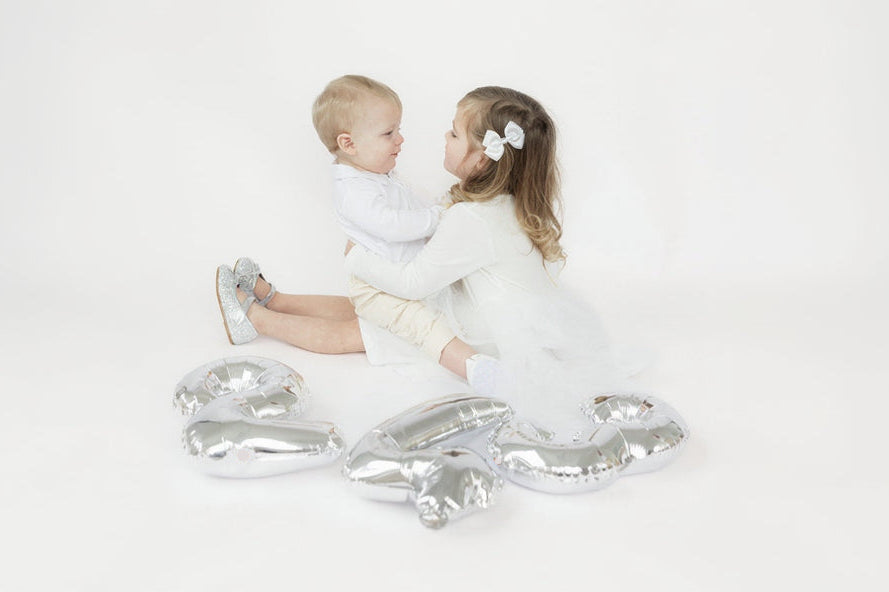 Two children sitting with balloons for 243 baby luxury brand