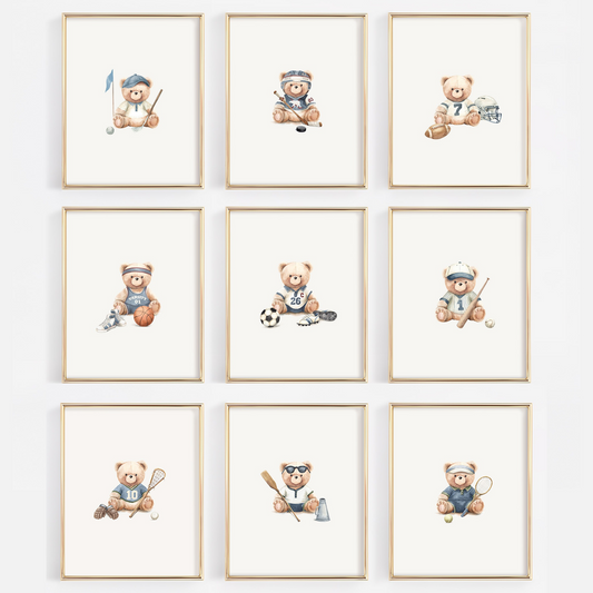 A 3x3 grid of nine framed watercolor prints featuring teddy bears playing sports, displayed on a light gray wall. Each print has a light wood frame and shows a different sport such as soccer, lacrosse, tennis, baseball, football, hockey, basketball, golf, crew, tennis.