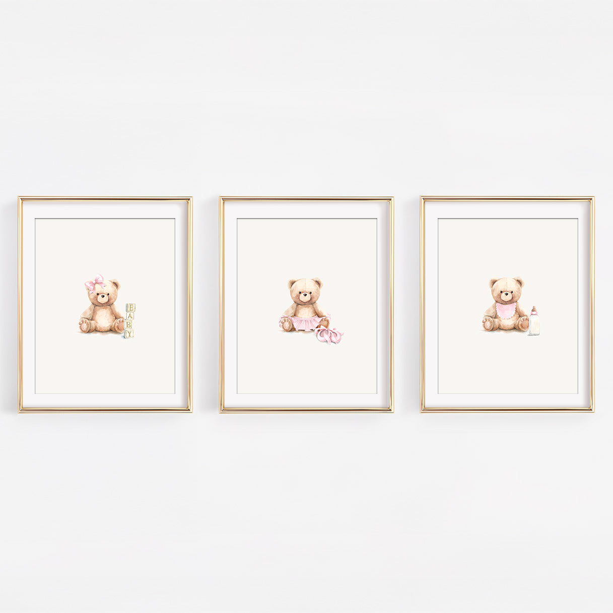 Set of three watercolor blush pink teddy bear prints for a girl's nursery, featuring a ballerina bear in a tutu, a bear with blocks, and a bear with a bib and bottle.
