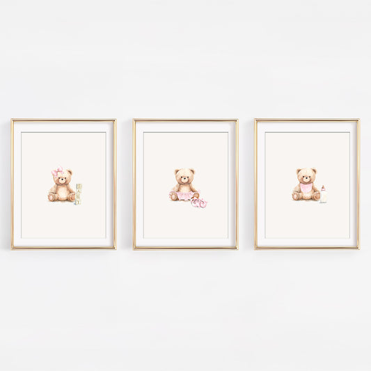 Set of three watercolor blush pink teddy bear prints for a girl's nursery, featuring a ballerina bear in a tutu, a bear with blocks, and a bear with a bib and bottle.