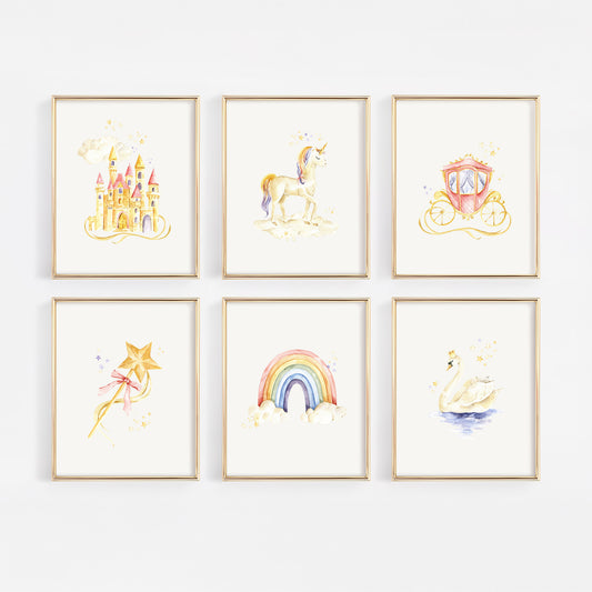 Six framed watercolor art prints arranged in a 2x3 grid on a white wall. The prints feature whimsical illustrations of a castle, unicorn, carriage, wand, rainbow, and swan in soft pastel colors with gold-toned frames.