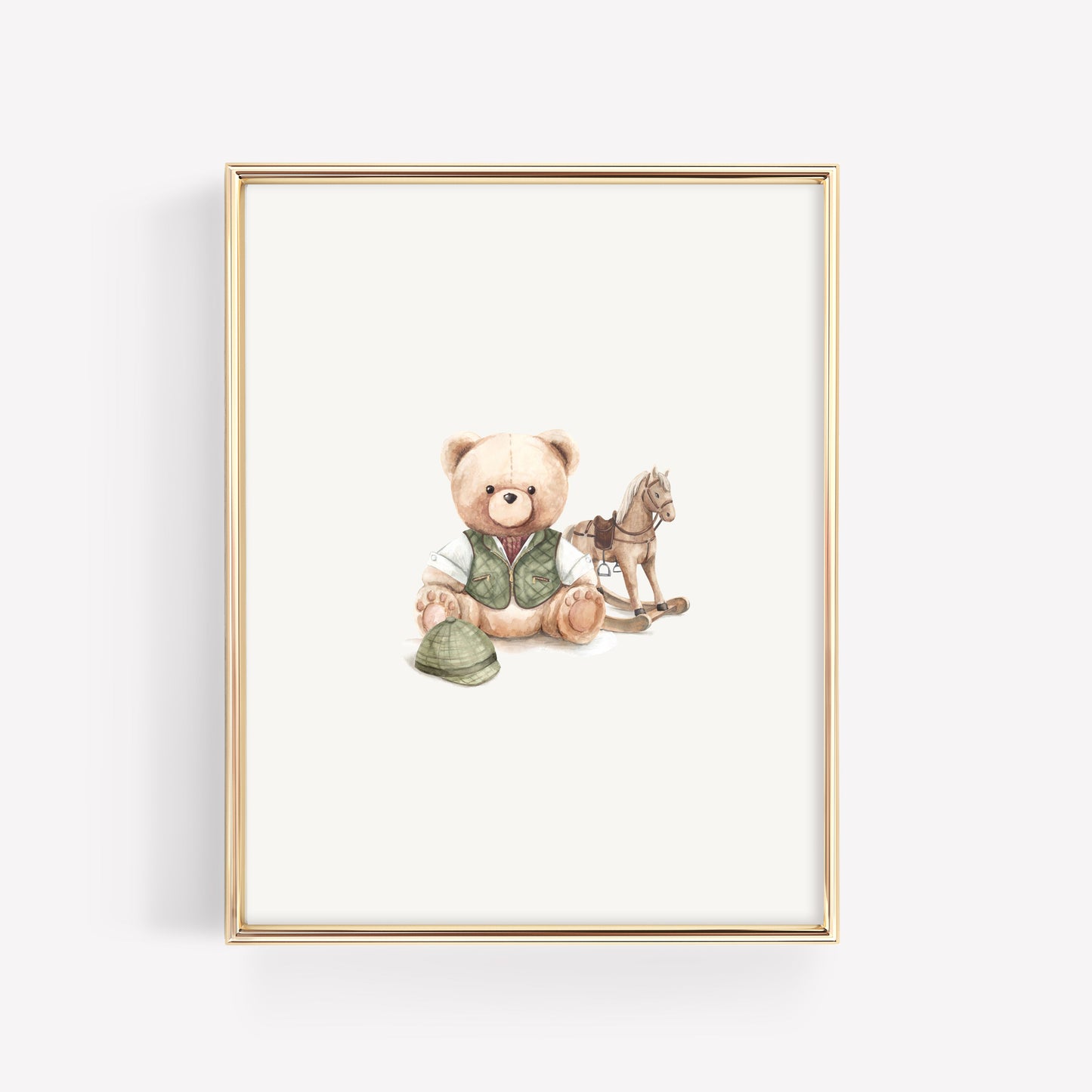 A framed art print featuring a watercolor illustration of a teddy bear wearing a vest and holding a hat, sitting next to a rocking horse, in a thin gold frame against a white background.