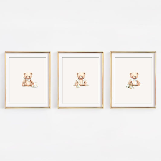 Set of three watercolor frost grey teddy bear nursery prints featuring bears with baby blocks, a rattle, and a binky. Elegant blue and silver decor for a baby boy.