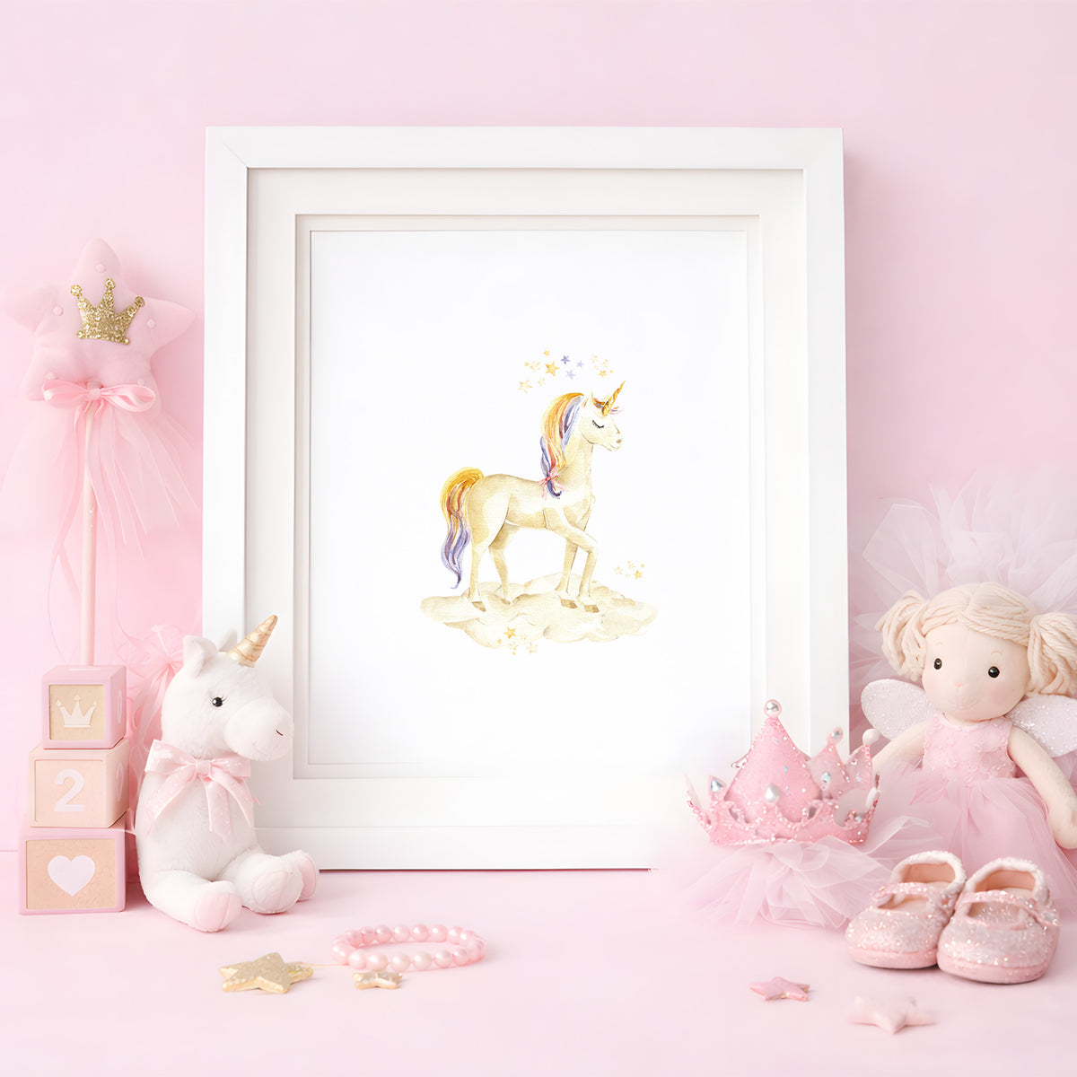 Framed watercolor art print of a magical golden unicorn standing on a cloud, styled in a pink nursery decor setup with a plush unicorn and fairy doll.