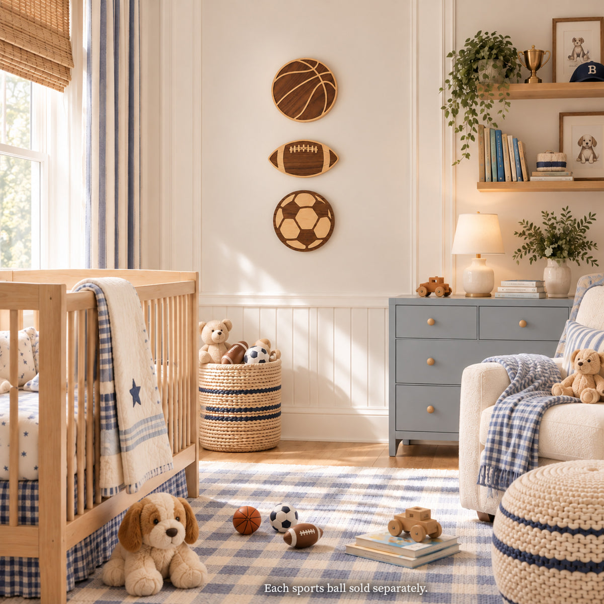 Sports-themed nursery featuring a set of three wooden wall decor signs—a basketball, football, and soccer ball—stacked vertically above a light wooden crib, blue dresser, and blue gingham rug.