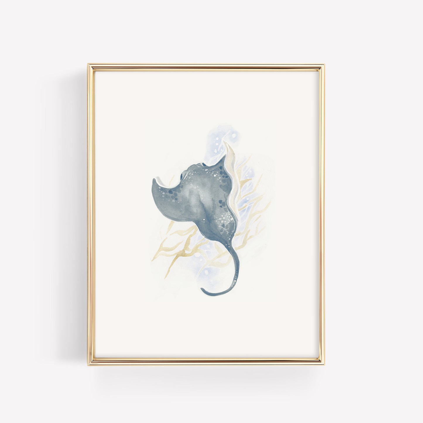 A graceful watercolor stingray in deep ocean blue shades, showcased in a thin gold nursery frame on a crisp white background for a modern sea life theme.