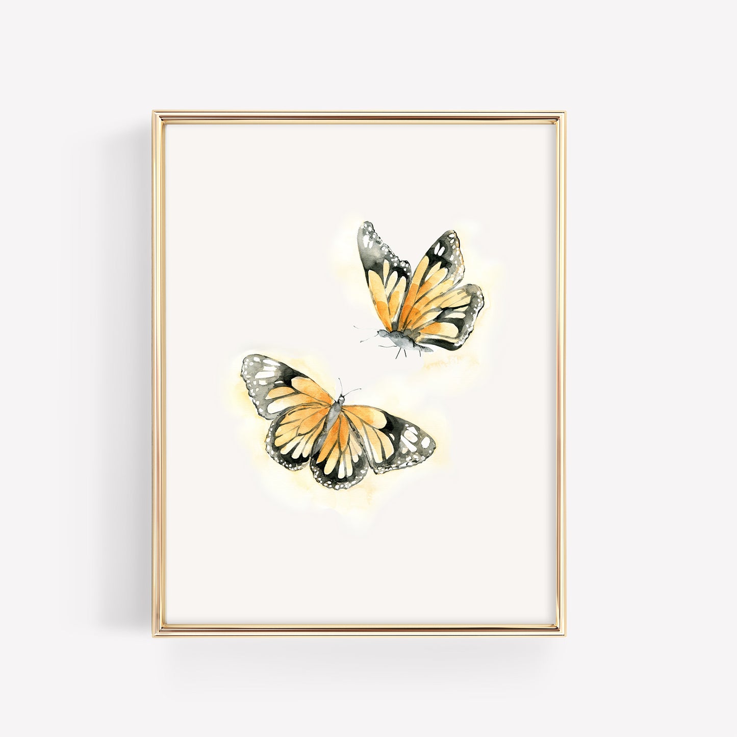 Two vibrant monarch butterflies in a vertical gold frame, featuring a soft watercolor orange glow and delicate black detailing on a clean white background.
