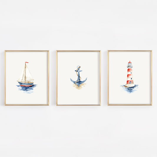 Three framed watercolor nautical art prints hanging on a white wall, featuring a sailboat, an anchor, and a red-and-white lighthouse.