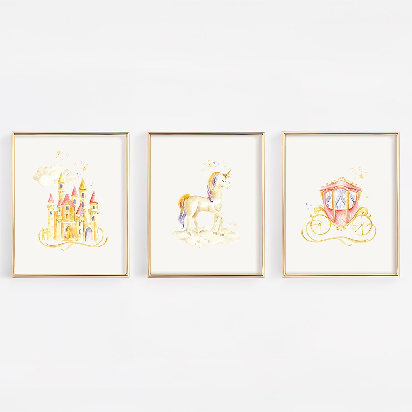 Three framed watercolor art prints featuring a golden castle, a unicorn, and a pink carriage, displayed side-by-side on a white wall.