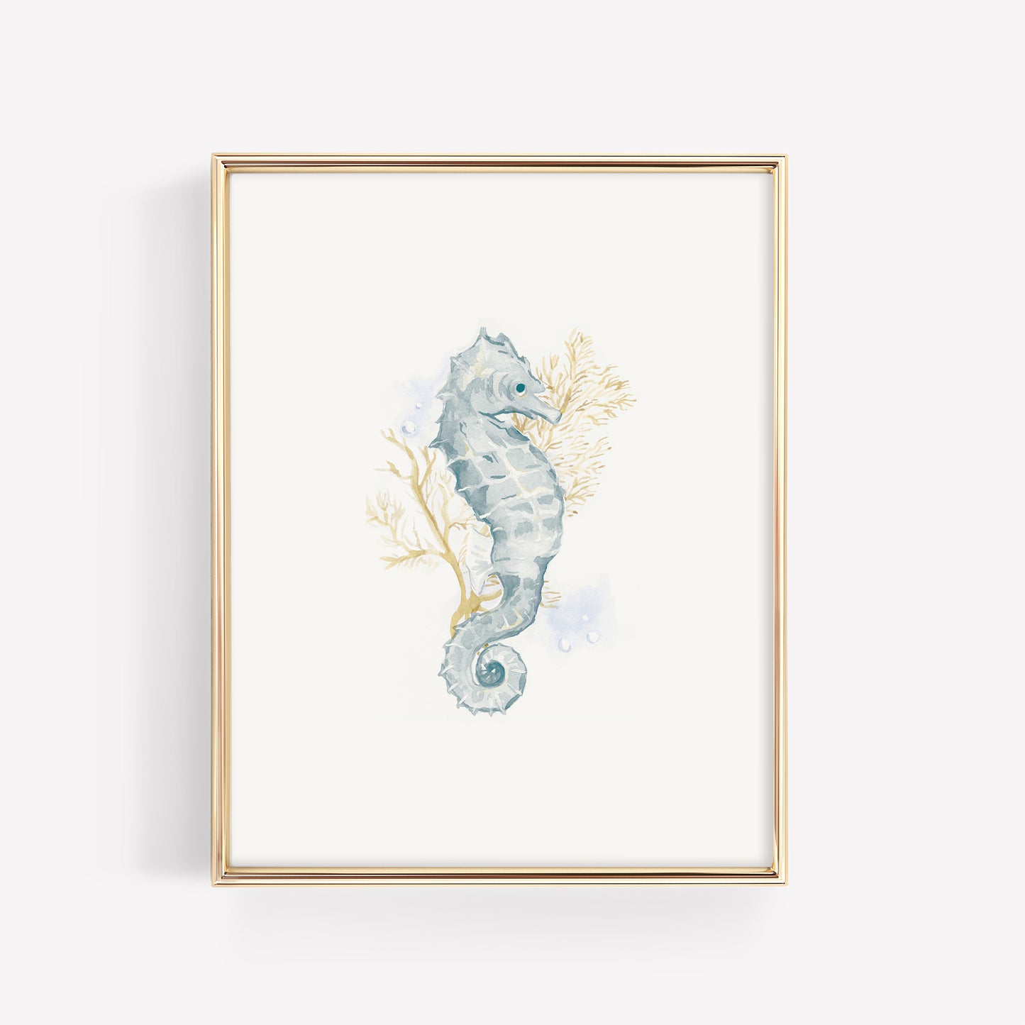 A dainty watercolor seahorse in soft blue and teal tones swimming near a branch of vibrant gold coral, featured in a sleek metallic gold frame for a coastal baby room.