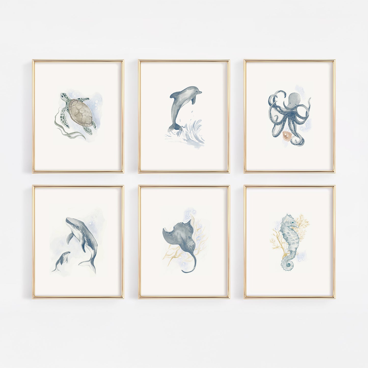 A complete nursery gallery wall set of six gold-framed prints featuring watercolor sea creatures: a sea turtle, mother and baby humpback whale, playful dolphin, octopus with an oyster pearl, seahorse with coral, and a graceful blue stingray.