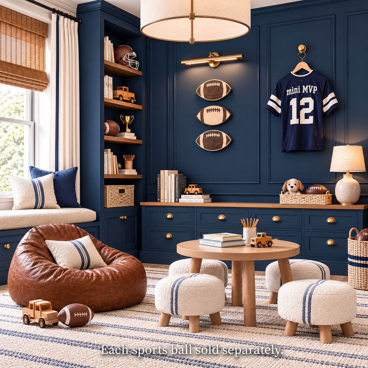 A vintage football-themed kids' playroom with navy blue paneled walls and custom built-in shelving and cabinets[cite: 22]. In the center, three decorative wooden football wall art pieces are vertically stacked and illuminated by a brass library light
