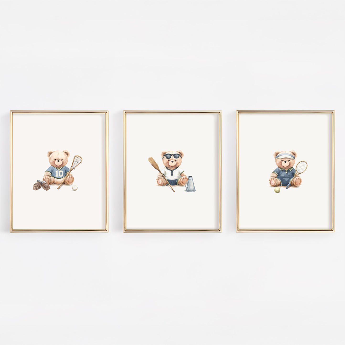 Three framed watercolor prints of teddy bears playing sports, displayed side-by-side on a white wall. The left bear plays lacrosse, the middle bear rows crew and the right bear plays tennis.
