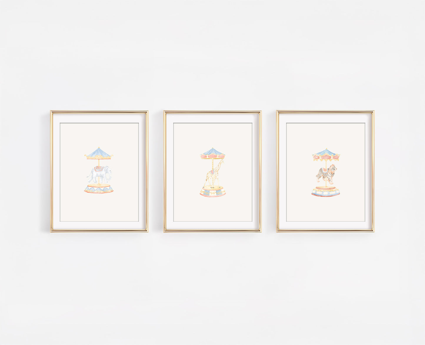 Set of three watercolor carousel animal nursery prints featuring a tiger, giraffe, and elephant on merry-go-round poles. Whimsical carnival themed baby room decor in soft gold, blush, and blue tones.