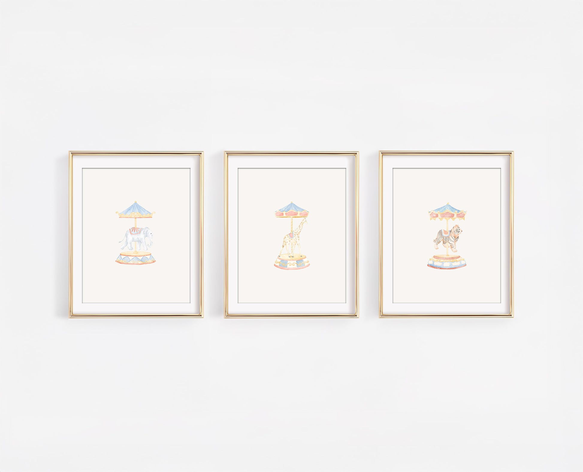 Set of three watercolor carousel animal nursery prints featuring a tiger, giraffe, and elephant on merry-go-round poles. Whimsical carnival themed baby room decor in soft gold, blush, and blue tones.